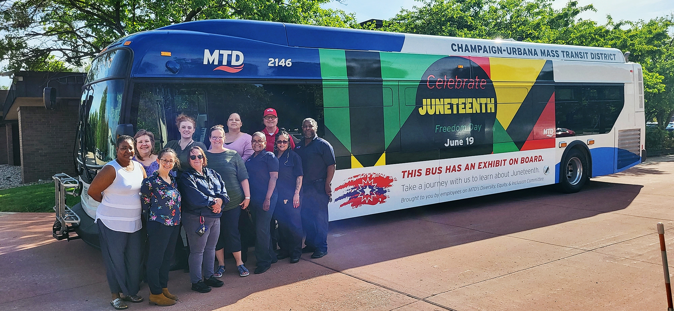 Several employees from MTD’s Diversity, Equity, and Inclusion Committee posing with the Juneteenth Bus.